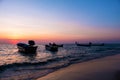 Silhouette of fishing boat on tropical beach at sunset. Royalty Free Stock Photo