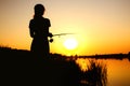 Silhouette of a fishing woman on the river bank on the nature at dawn Royalty Free Stock Photo