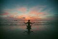 Silhouette of fitnes woman practicing yoga on the sea beach at amazing sunset Royalty Free Stock Photo