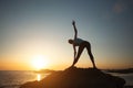 Silhouette fitness lady doing gymnastics by the ocean during a beautiful sunsetÃÅ½