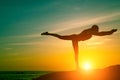 Silhouette of fitness woman doing exercises on the sea beach during amazing sunset. Royalty Free Stock Photo