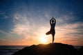 Silhouette of fitness yoga woman doing exercises on the sea beach during sunset Royalty Free Stock Photo