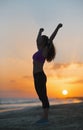 Silhouette of fitness young woman rejoicing on beach at dusk Royalty Free Stock Photo