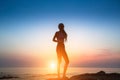 Silhouette flexible girl moves in a dance on the shore of the sea