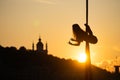 Silhouette of a flexible woman acrobat on aerial silk during a sunset on Kiev city background. concept of freedom and