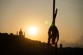 Silhouette of a flexible woman acrobat on aerial silk during a sunset on Kiev city background. concept of freedom and