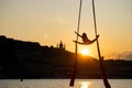 Silhouette of a flexible woman acrobat on aerial silk during a sunset on Kiev city background. concept of freedom and