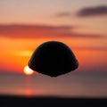 Silhouette of a floating turtle shell against a vibrant sunset Royalty Free Stock Photo