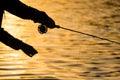Silhouette of fly fisherman at sunset