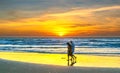 A silhouette of a foreign tourist couple happily walking together along a white sand beach Royalty Free Stock Photo