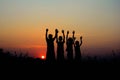 silhouette of four children standing together. There is a sky at sunset background Royalty Free Stock Photo