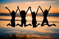 Four girls silhouette jumping on the beach with the sunset in the background. Royalty Free Stock Photo