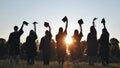 Silhouette of fresh graduates throwing their motarboard or trencher up in the air after their graduation.