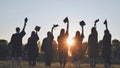 Silhouette of fresh graduates throwing their motarboard or trencher up in the air after their graduation.