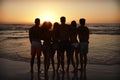 Silhouette Of Friends On Beach Vacation Watching Sunset Over Sea Royalty Free Stock Photo