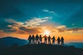 Silhouette of friends holding hands over orange sunset