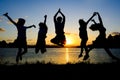 Silhouette of friends jumping in sunset