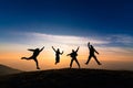 Silhouette of friends jumping in sunset for happiness,fun and te