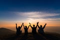 Silhouette of friends shake hands up and sitting together in sun