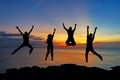 Silhouette of friends and teamwork jumping on beach during sunset time for success business. Royalty Free Stock Photo