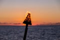 A silhouette of a gas torch with flame around it against scenic sunset Royalty Free Stock Photo