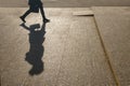 Silhouette of a girl on the background of a city street. A large shadow of a woman walking with a bag. A woman in a hurry on their Royalty Free Stock Photo