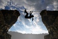 Silhouette girl climbs on a rope over an abyss