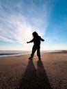 Silhouette of girl dancing on the beach at sunset in autumn Royalty Free Stock Photo