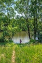 Silhouette of a girl descending from a hill to the river. Royalty Free Stock Photo