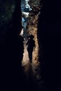 Silhouette Girl exploring huge cave. Adventure traveller dressed cowboy hat and backpack, leather jacket. vertical photo, tourist Royalty Free Stock Photo