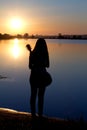 Silhouette of girl with a guitar by the river Royalty Free Stock Photo