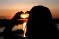 silhouette of a girl and hands forming a heart shape with sunset Royalty Free Stock Photo