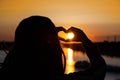 silhouette of hands forming a heart shape with sunset. expression of love and gratitude to the world. Royalty Free Stock Photo