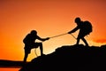 Silhouette of girl helping man teamwork success on top mountain