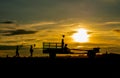 Silhouette of girl hold small windmill and stand on E-taen farm tractor with driver and follow by other children walk in the back