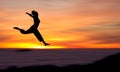 Silhouette of girl jumping in sunset