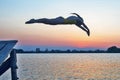 Silhouette of a girl jumping into the water in the evening Royalty Free Stock Photo