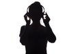 Silhouette of a girl listening to music in headphones on a white isolated background Royalty Free Stock Photo