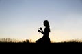 Silhouette of Girl Outside Picking Flowers in Meadow Royalty Free Stock Photo