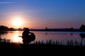 Silhouette of a girl playing the guitar by the river Royalty Free Stock Photo