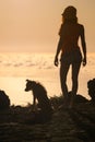 Silhouette of girl with puppy on sunset