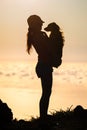 Silhouette of girl with puppy on sunset