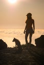 Silhouette of girl with puppy on sunset