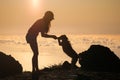 Silhouette of girl with puppy on sunset