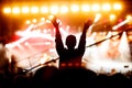 Silhouette of a girl with raised hands at a mass event. Party in a nightclub