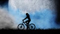 Silhouette of a girl riding a bicycle against the background of a blue moon. Royalty Free Stock Photo