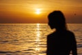 Silhouette of a girl's profile in out of focus against the background of the sea