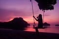 Silhouette of a girl sitting on a swing or cradle on the beach at sunset Royalty Free Stock Photo
