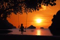 Silhouette of a girl sitting on a swing or cradle on the beach at sunset Royalty Free Stock Photo