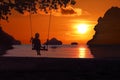 Silhouette of a girl sitting on a swing or cradle on the beach at sunset Royalty Free Stock Photo